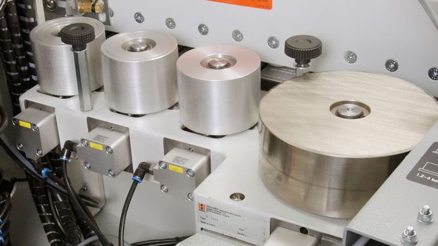 Motor-driven 4-roller pressure unit With automatic adaptation to feed rate and NC servo-axes for motor-driven adjustment to correct edge thickness.