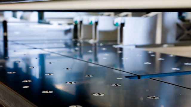 Air-conditioned machine table with air cushions in front of and behind the saw line